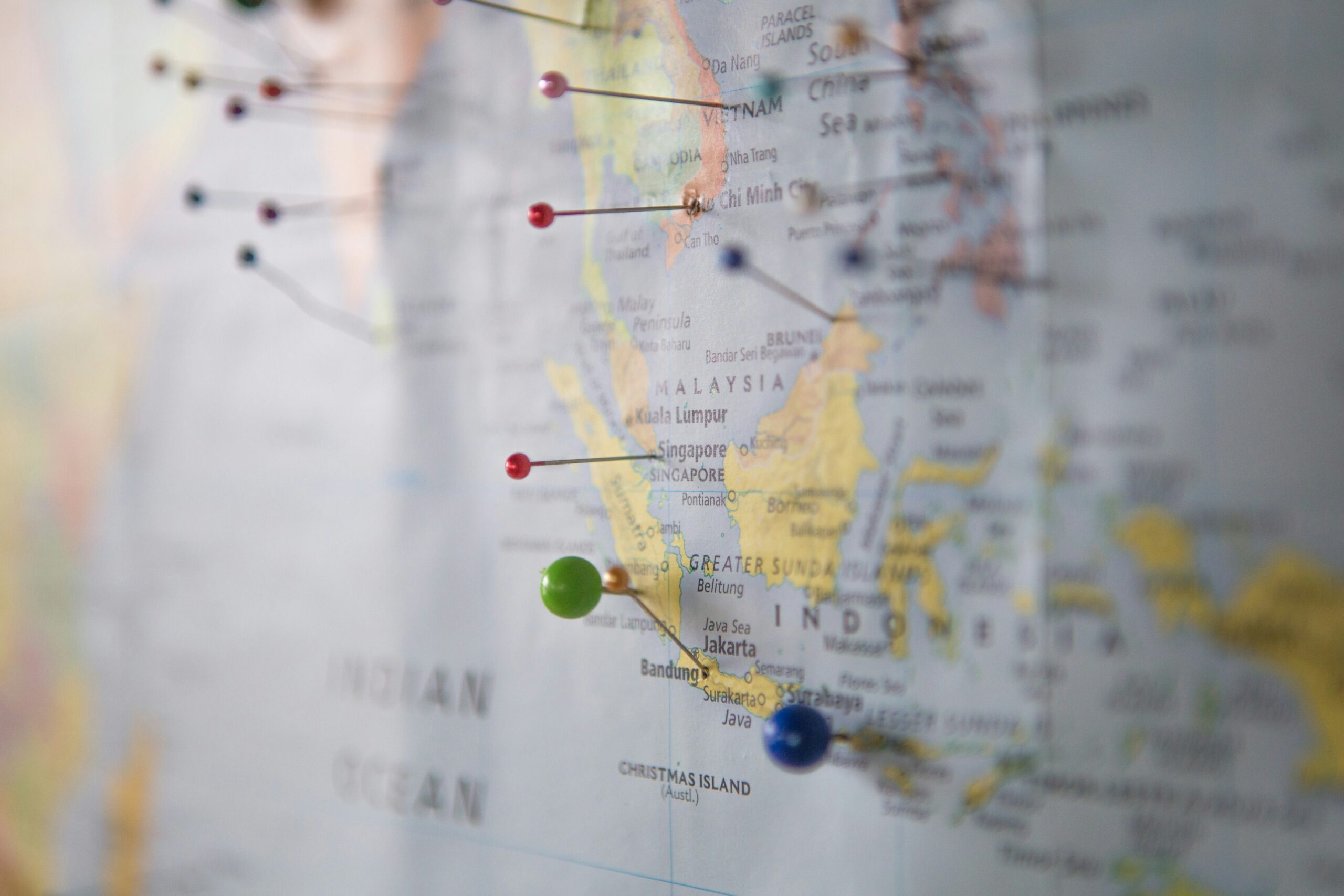 A close up image of a world map with several pins it in.