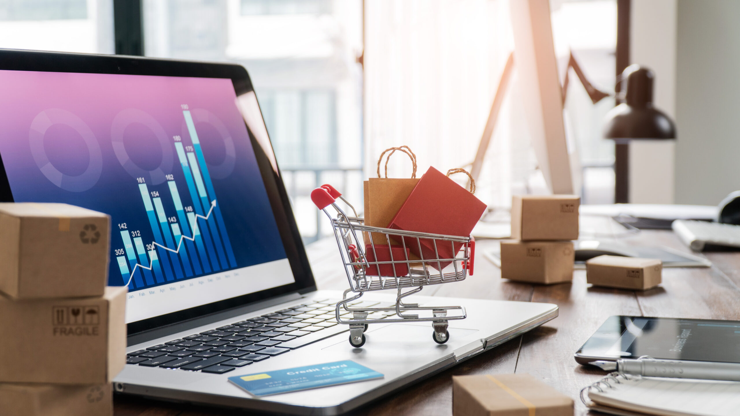 Shopping bags in shopping cart and credit card on laptop